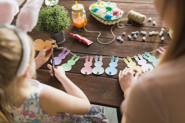 Mutter und Tochter, die Häschen vom Papier schneiden