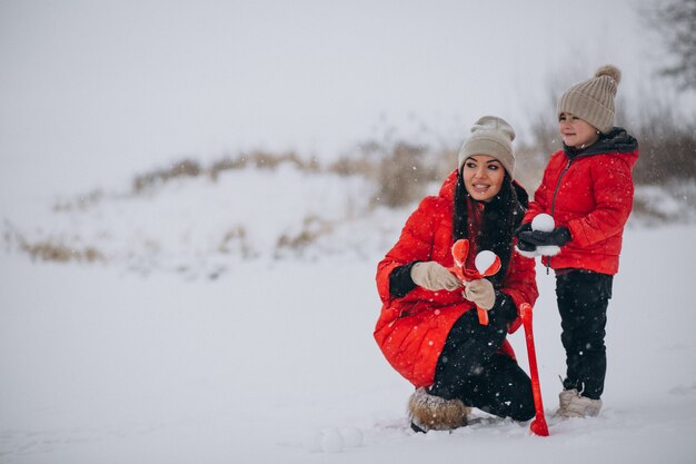 Mutter und Tochter, die im Winterpark spielen