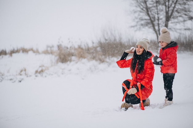 Mutter und Tochter, die im Winterpark spielen