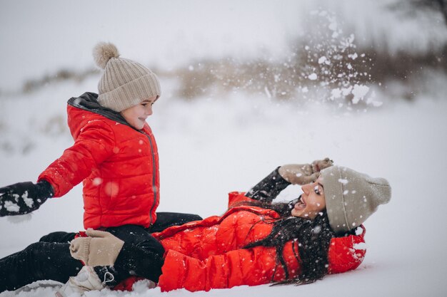 Mutter und Tochter, die im Winterpark spielen