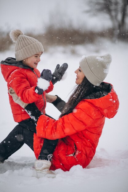 Mutter und Tochter, die im Winterpark spielen