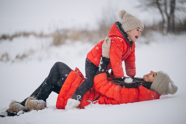 Mutter und Tochter, die im Winterpark spielen