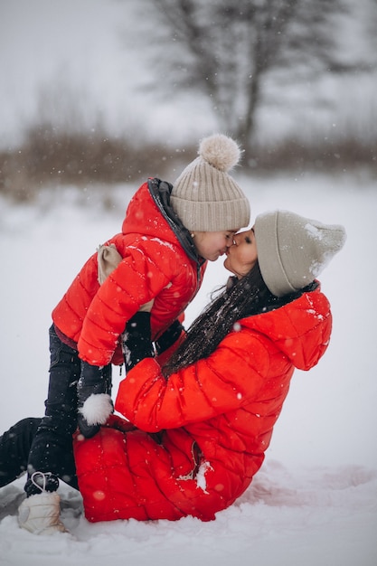 Mutter und Tochter, die im Winterpark spielen