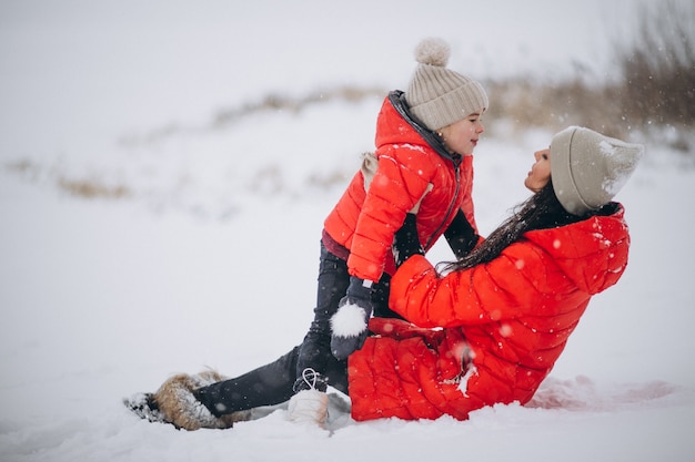 Mutter und Tochter, die im Winterpark spielen