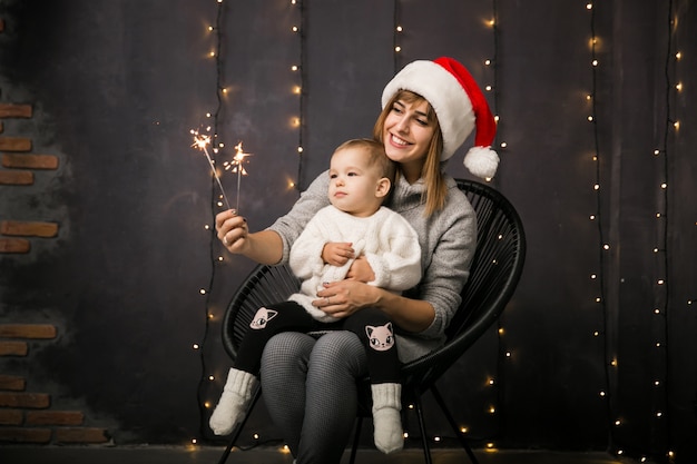 Mutter und Tochter, die in einem Stuhl auf Weihnachten sitzen