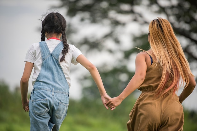 Mutter und Tochter, die um den Park spielen und laufen