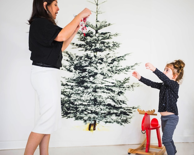 Mutter und Tochter, die Weihnachtsbaum verzieren