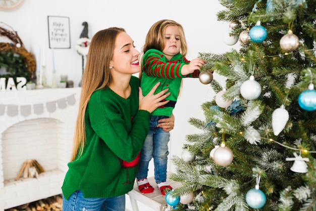 Mutter und Tochter, die Weihnachtsbaum verzieren