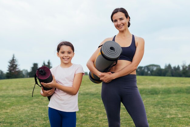 Mutter und Tochter, die Yogamatten halten