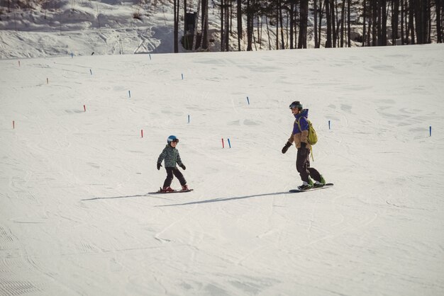 Mutter und Tochter fahren auf schneebedeckten Alpen Ski