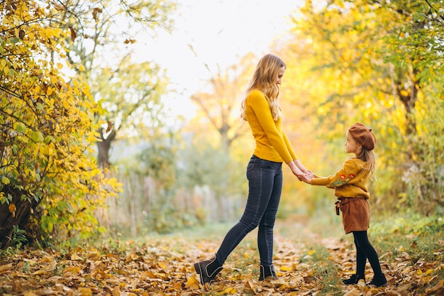 Mutter und Tochter im Park voller Blätter