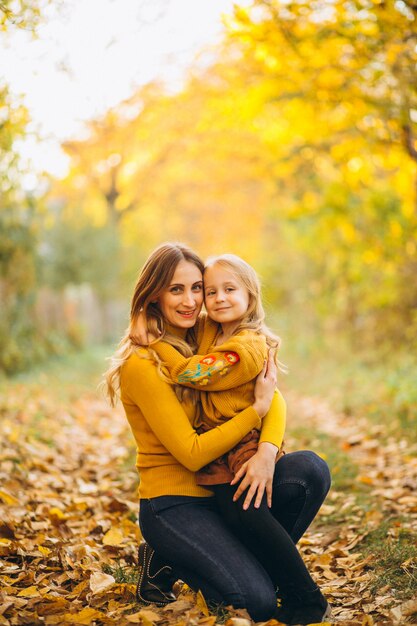 Mutter und Tochter im Park voller Blätter