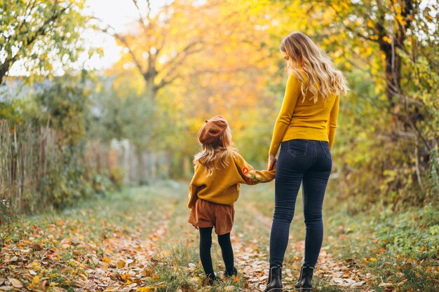 Mutter und Tochter im Park voller Blätter