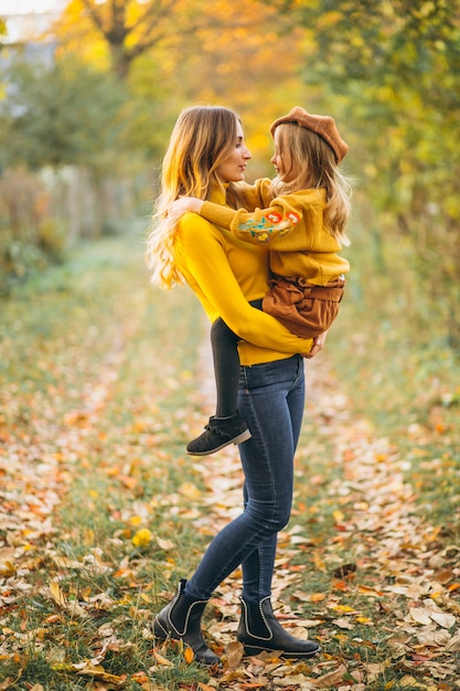 Mutter und Tochter im Park voller Blätter