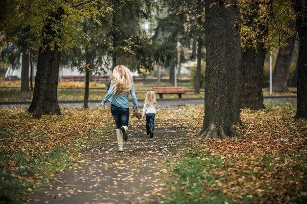 Mutter und Tochter in den Park läuft