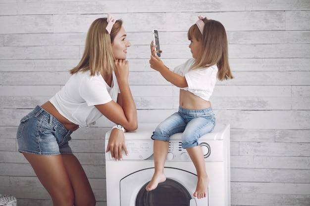 Mutter und Tochter in einem Badezimmer in der Nähe von Waschmaschine