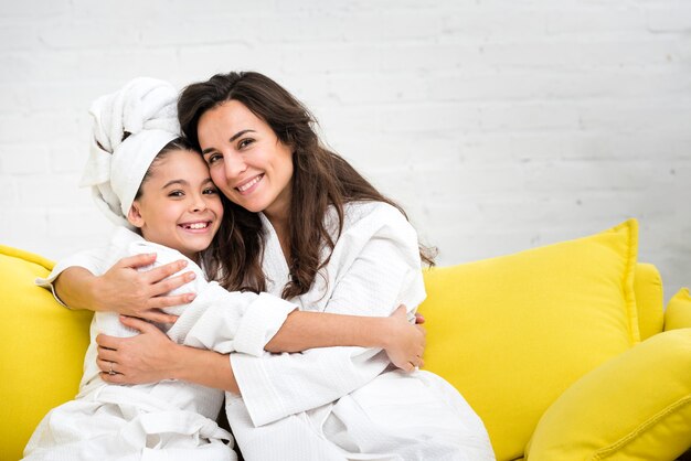 Mutter und Tochter in Roben umarmen