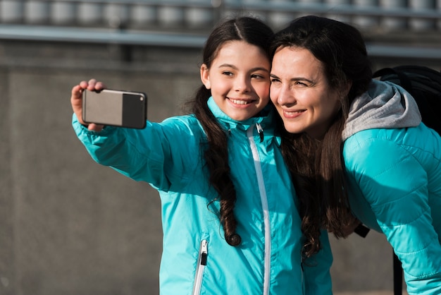 Mutter und Tochter machen ein Selfie im Freien