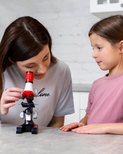 Mutter und Tochter machen Experimente mit dem Mikroskop