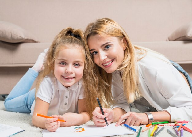 Mutter und Tochter malen auf dem Boden