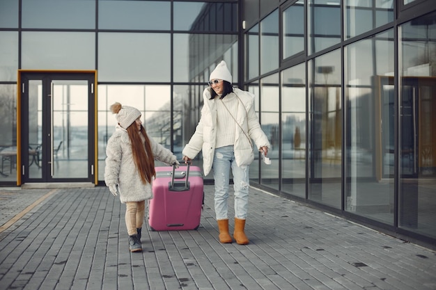 Mutter und Tochter mit Gepäck vom Flughafenterminal