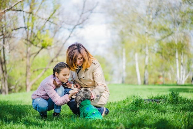 Mutter und Tochter mit Hund im Park