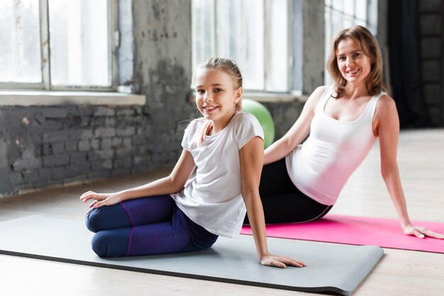 Mutter und Tochter praktizieren Yoga