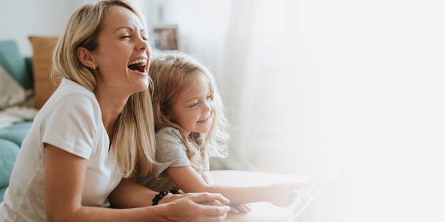 Mutter und Tochter schauen sich einen Cartoon auf einem digitalen Tablet an