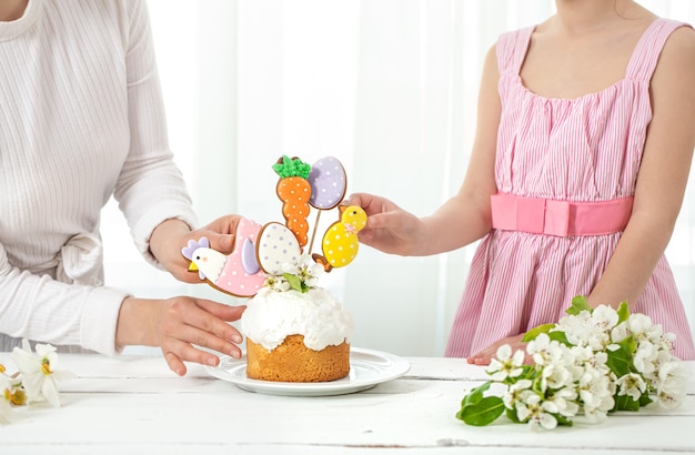 Mutter und Tochter schmücken den Paksal-Kuchen. Das Konzept der Vorbereitung auf den Familienurlaub Ostern.