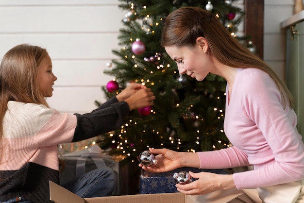 Kostenloses Foto mutter und tochter schmücken den weihnachtsbaum