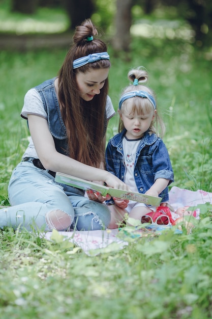 Mutter und Tochter sitzen auf dem Boden ein Buch zu lesen