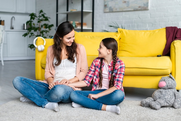 Mutter und Tochter sitzen auf dem Boden