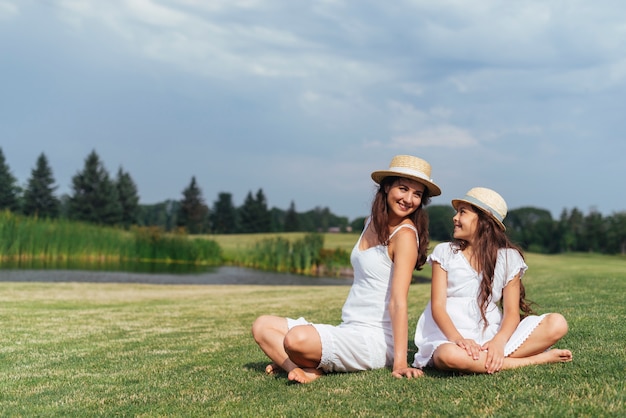 Mutter und Tochter sitzen zusammen in der Natur