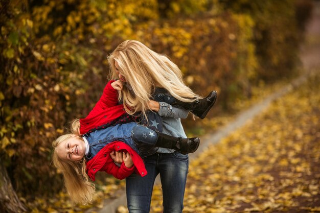 Mutter und Tochter spielen an einem Herbsttag