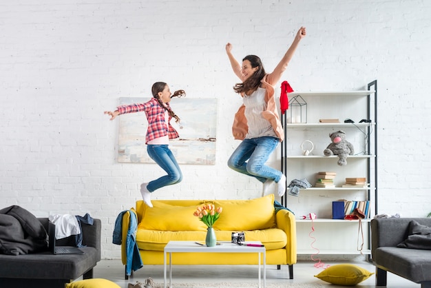 Mutter und Tochter springen auf die Couch