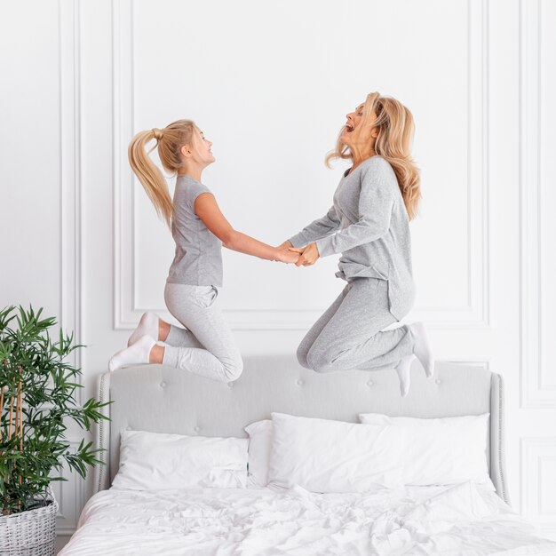 Mutter und Tochter springen im Bett
