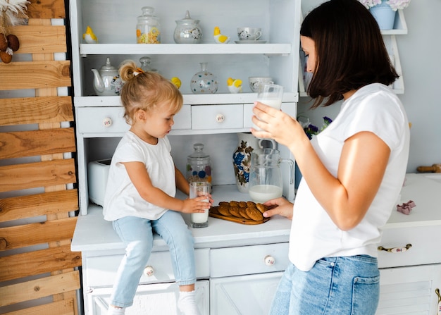 Mutter und Tochter trinken Milch und essen Kekse