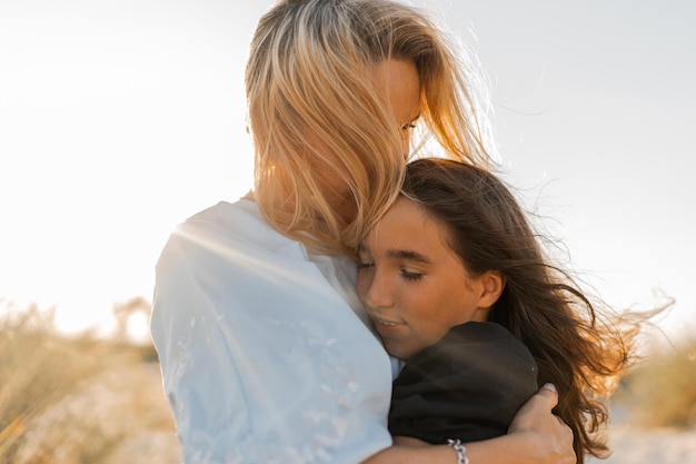 Mutter und Tochter umarmen sich am Strand Muttertag liebt Familie Elternschaft Kindheit Konzept