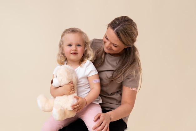 Mutter und Tochter zeigen Aufkleber am Arm, nachdem sie einen Impfstoff bekommen haben