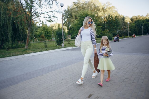 Mutter und Tochter zu Fuß, während das Mädchen in eine Tablette aussieht