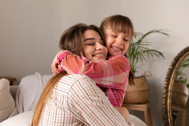 Mutter und Tochter zu Hause umarmen sich