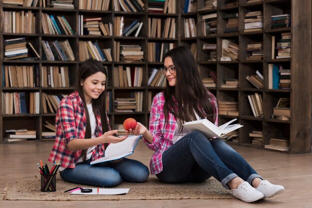 Kostenloses Foto mutter und tochter zusammen in der bibliothek