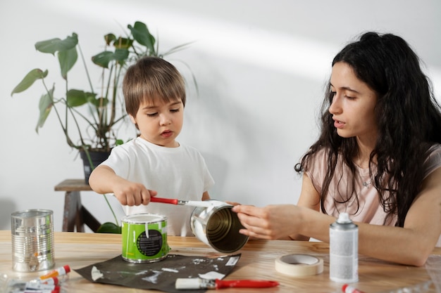 Mutter zeigt Kind, wie man Materialien auf kreative Weise wiederverwenden kann
