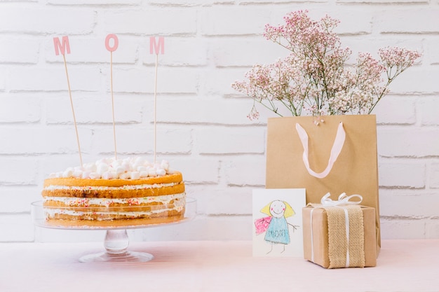 Muttertagkonzept mit geschmackvollem Kuchen und Blumen in der Tasche