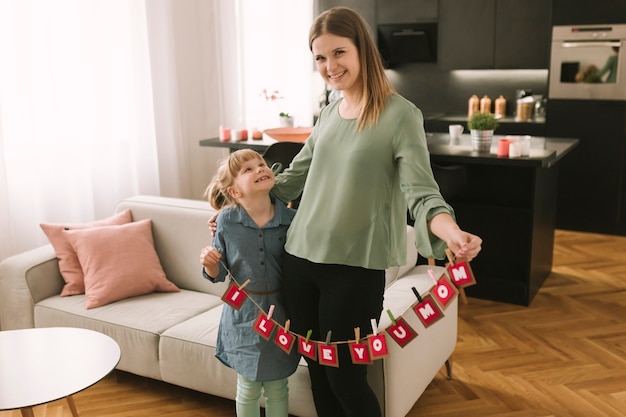 Muttertagkonzept mit Mutter und Tochter im Wohnzimmer