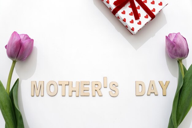 Muttertagsschriftzug mit Rosen und Geschenkkarton
