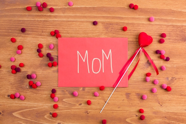 Muttertitel auf rosa Papier nahe dekorativem Herzen