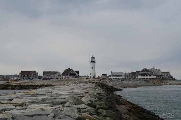 Nachbarschaft mit altem Scituate Light, das hoch steht.