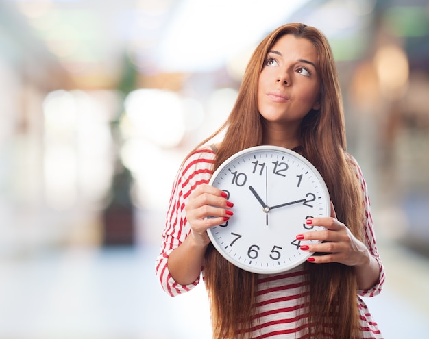 Kostenloses Foto nachdenklich mädchen mit einer uhr