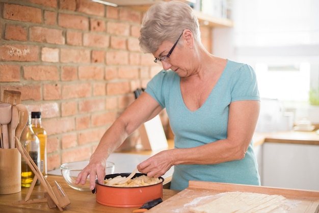 Nachdenkliche Großmutter backt köstlichen Apfelkuchen